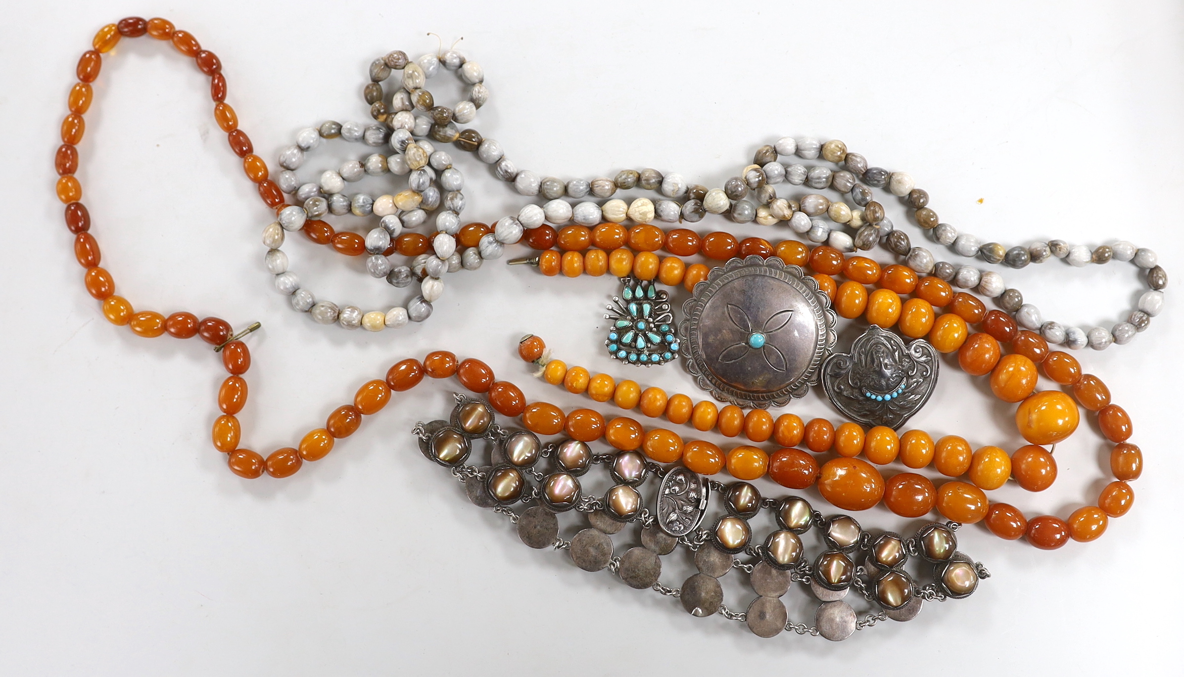 Two graduated amber bead necklaces, 100cm and 41cm, gross weight 116 grams, together with other jewellery including a white metal and mother of pearl set necklace.
